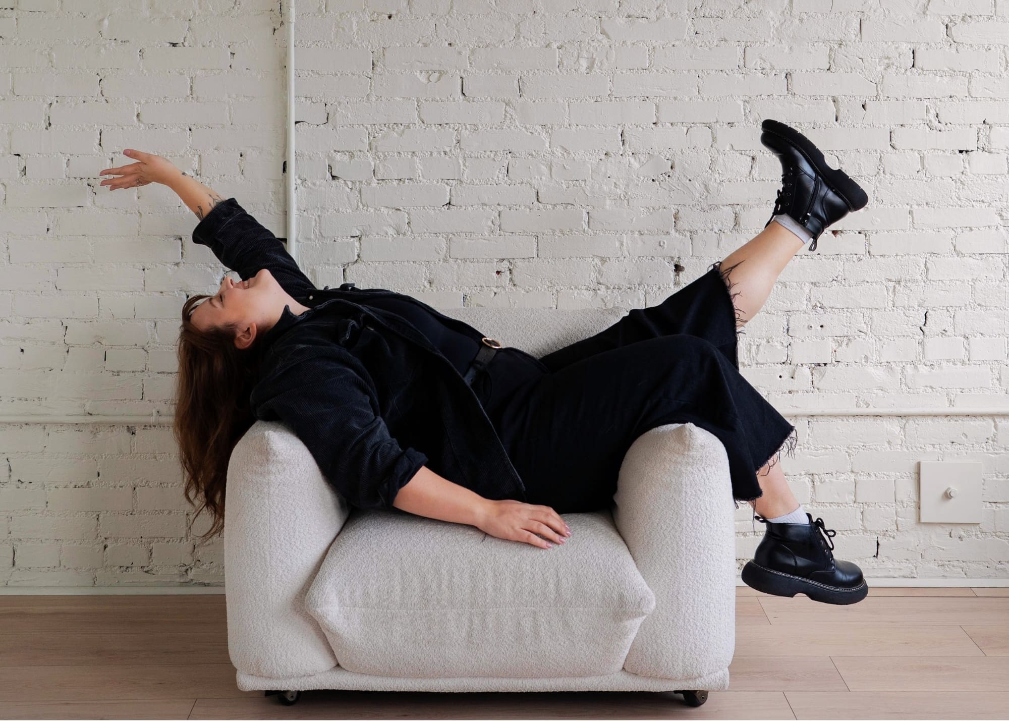 Women laying on couch with her leg and arm up in the air being excited.